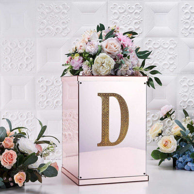Decorative floral arrangement in a mirrored box with a gold letter D.