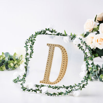 Gold rhinestone letter "D" surrounded by floral decor on a clear background.