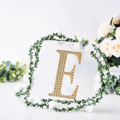 Gold letter "E" decor with floral wreath on a white background.