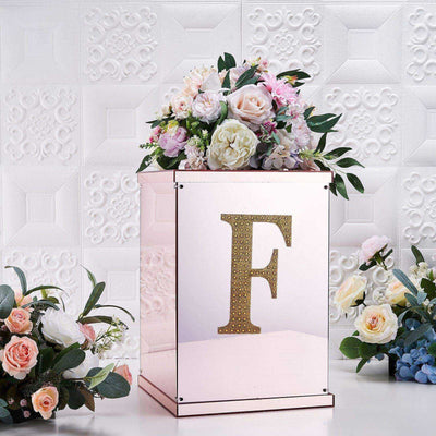 Mirrored floral display box with letter F and decorative flowers on top.