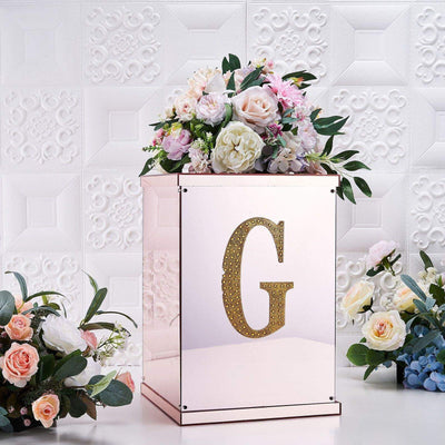 Rose gold flower box with floral arrangement and decorative letter "G"