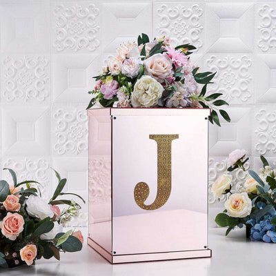 Elegant floral arrangement in a mirrored box with a decorative 'J' detail.