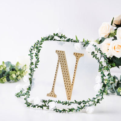 Gold letter "N" decor with floral wreath on a clear background.