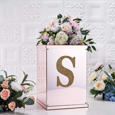 Rose gold decorative box with floral arrangement and letter "S" embellishment.