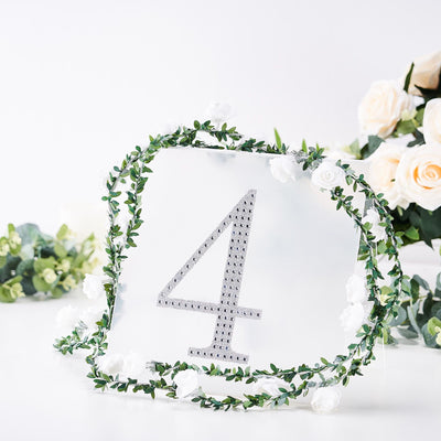 Decorative table number 4 surrounded by faux greenery and white flowers