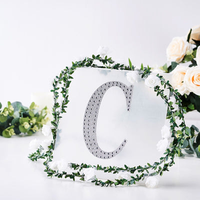 Decorative acrylic letter "C" surrounded by floral arrangement