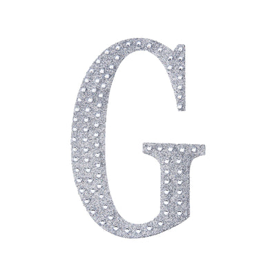 Silver glitter letter G cutout on a white background.