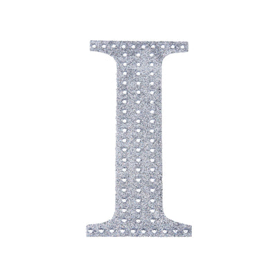 Silver letter "I" cutout with holes on a plain white background.