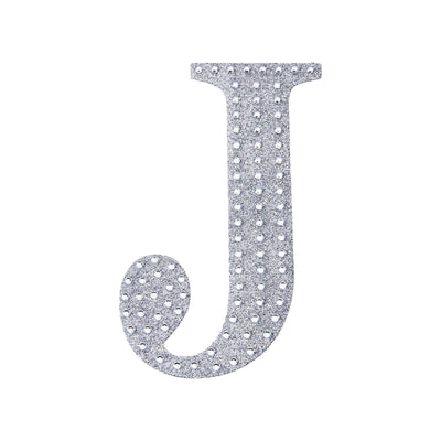 Silver letter J with rhinestones on a plain white background