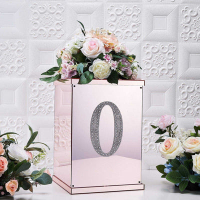 Rose gold floral arrangement box with number "0" and decorative flowers.
