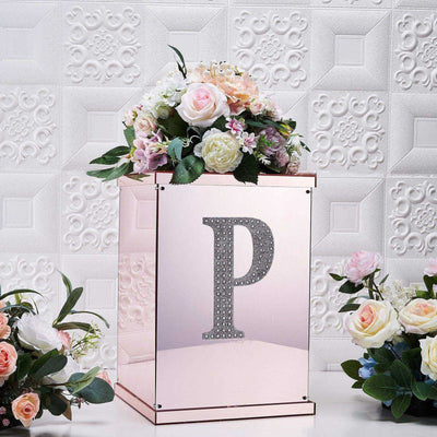 Decorative flower box with rhinestone "P" and floral arrangements.