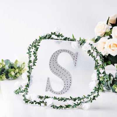 Decorative acrylic letter "S" surrounded by flowers and greenery.