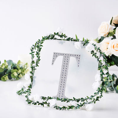 Decorative mirror with letter "T" surrounded by floral accents