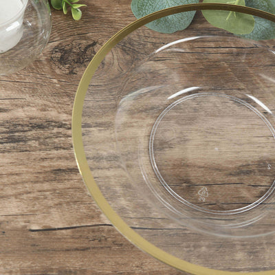 Clear glass bowl with gold rim on wooden surface.