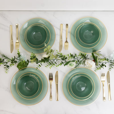 Elegant green dinnerware set with gold accents on a marble table setting.