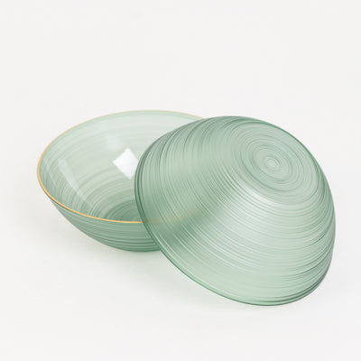 Green glass bowl with a swirling design, one lid partially removed.