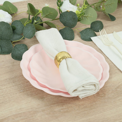 Elegant pink plates with napkin and ring on a wooden table setting.