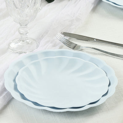 Light blue scalloped plates stacked on a table with cutlery.