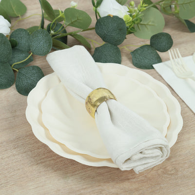 Elegant table setting with cream plates and a stylish napkin holder.