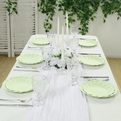 Elegant table setting with green plates and crystal glassware.