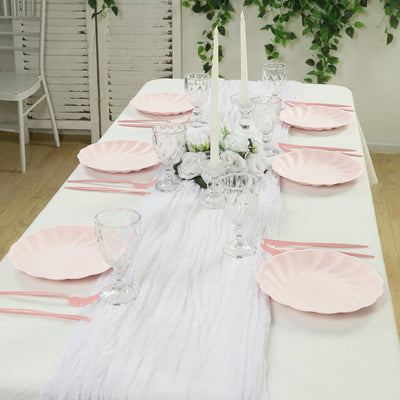 Elegant pink dinnerware set on a decorated table with floral centerpiece.