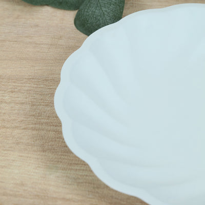 White scalloped ceramic plate on a wooden surface.