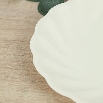 White scalloped serving dish on a wooden surface.