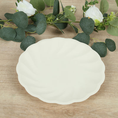 Cream scalloped edge plate with greenery backdrop.