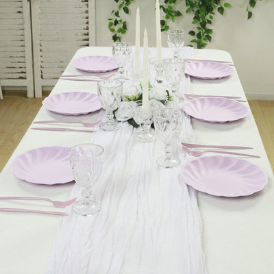 Elegant table setting with lavender plates, crystal glassware, and white candles.