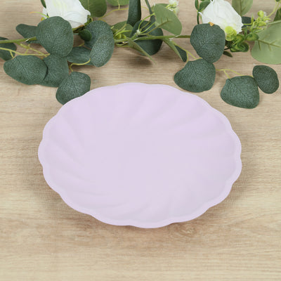 Pink scalloped plate on a wooden table with greenery.