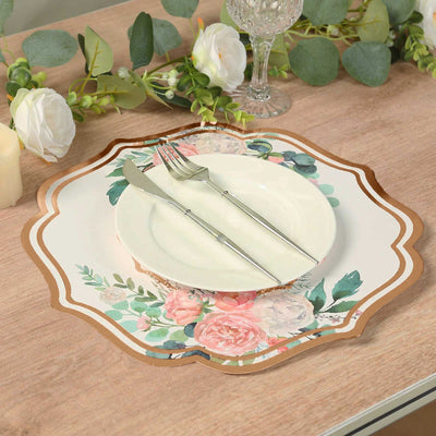 Floral design plate with cutlery on a wooden table setting.