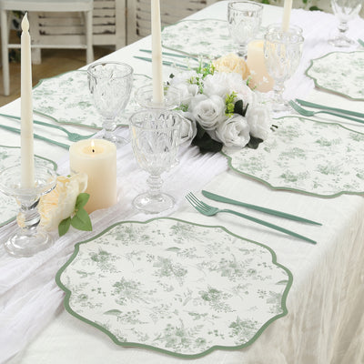 Elegant floral table setting with plates, candles, and crystal glassware.
