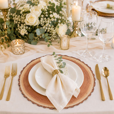 Elegant gold and white wedding table setting with floral centerpiece and candles