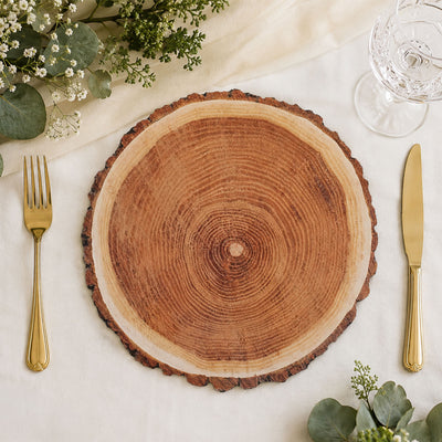 Rustic wood slice charger plate with gold flatware and greenery table decor