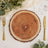 Rustic wood slice charger plate with gold flatware and greenery table decor