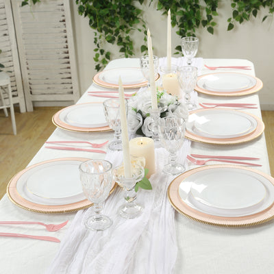 Elegant dining table setting with white plates and pink accents.