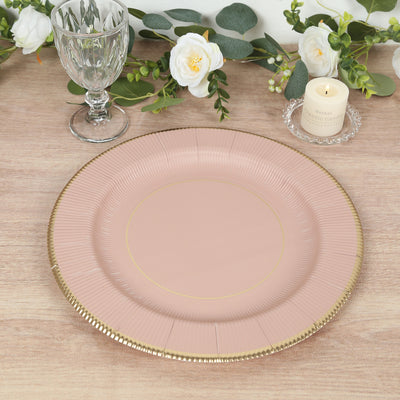 Elegant pink paper plate with gold trim on a wooden table.