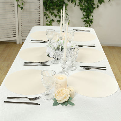 Elegant dining table setting with cream placemats, glassware, and floral accents.