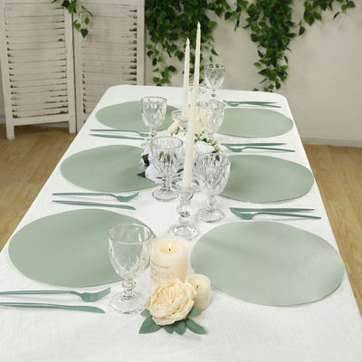 Elegant table setting with green placemats, glassware, candles, and floral decor.
