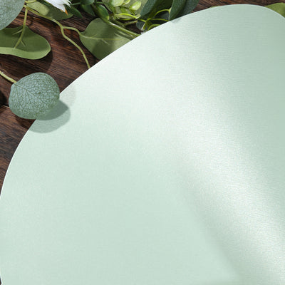 Mint green metallic textured surface with greenery accents.