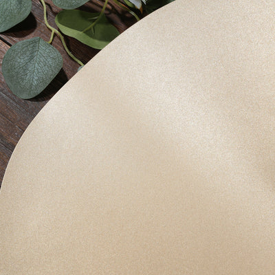 Gold glitter texture on a smooth surface with greenery accents.