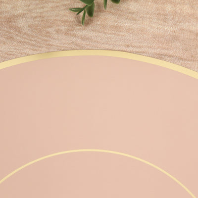 Pink and gold circular placemat on a wooden surface.