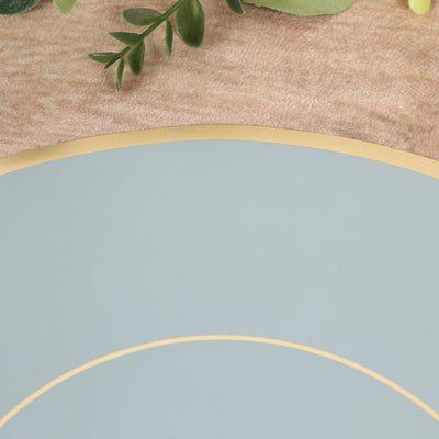 Decorative round plate in soft blue with gold trim on textured background.