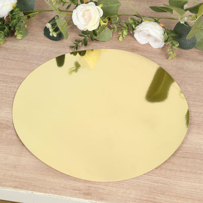 Gold oval mirror tray on a wooden surface with decorative flowers.