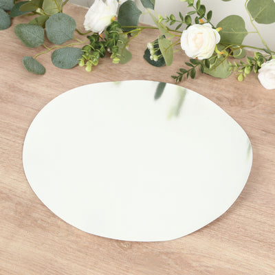 Round mirror plate on rustic wooden surface with greenery and flowers
