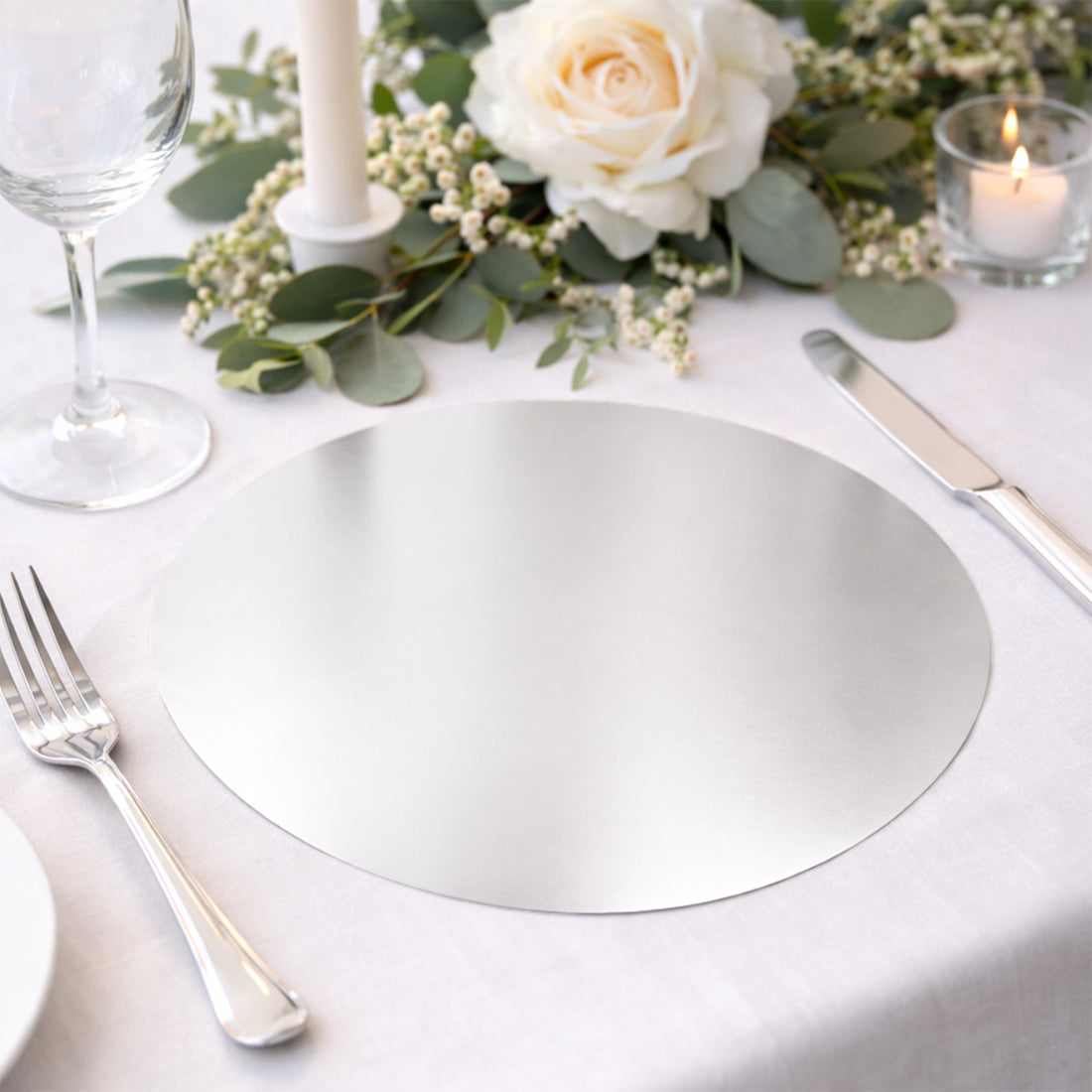 Elegant silver placemat on a beautifully set table with floral decor.
