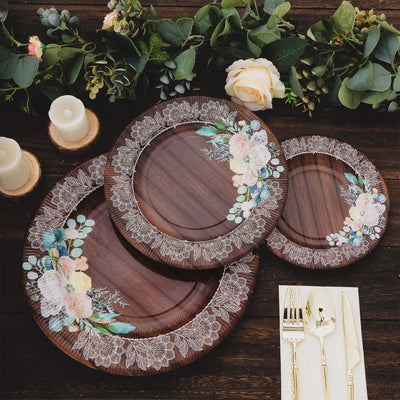 Floral design wooden plates set on a rustic table with candles and cutlery.