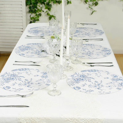 Elegant dining table set with blue floral plates and glassware.