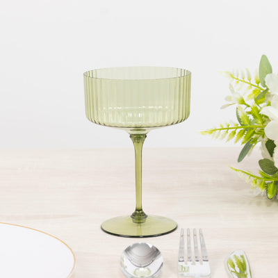 Green ribbed glass goblet on a table with floral decor