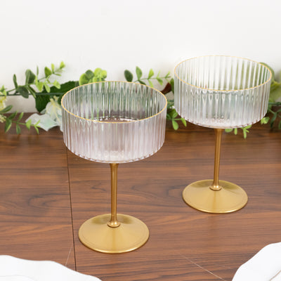 Elegant ribbed glass dessert cups with golden stems on a wooden table.